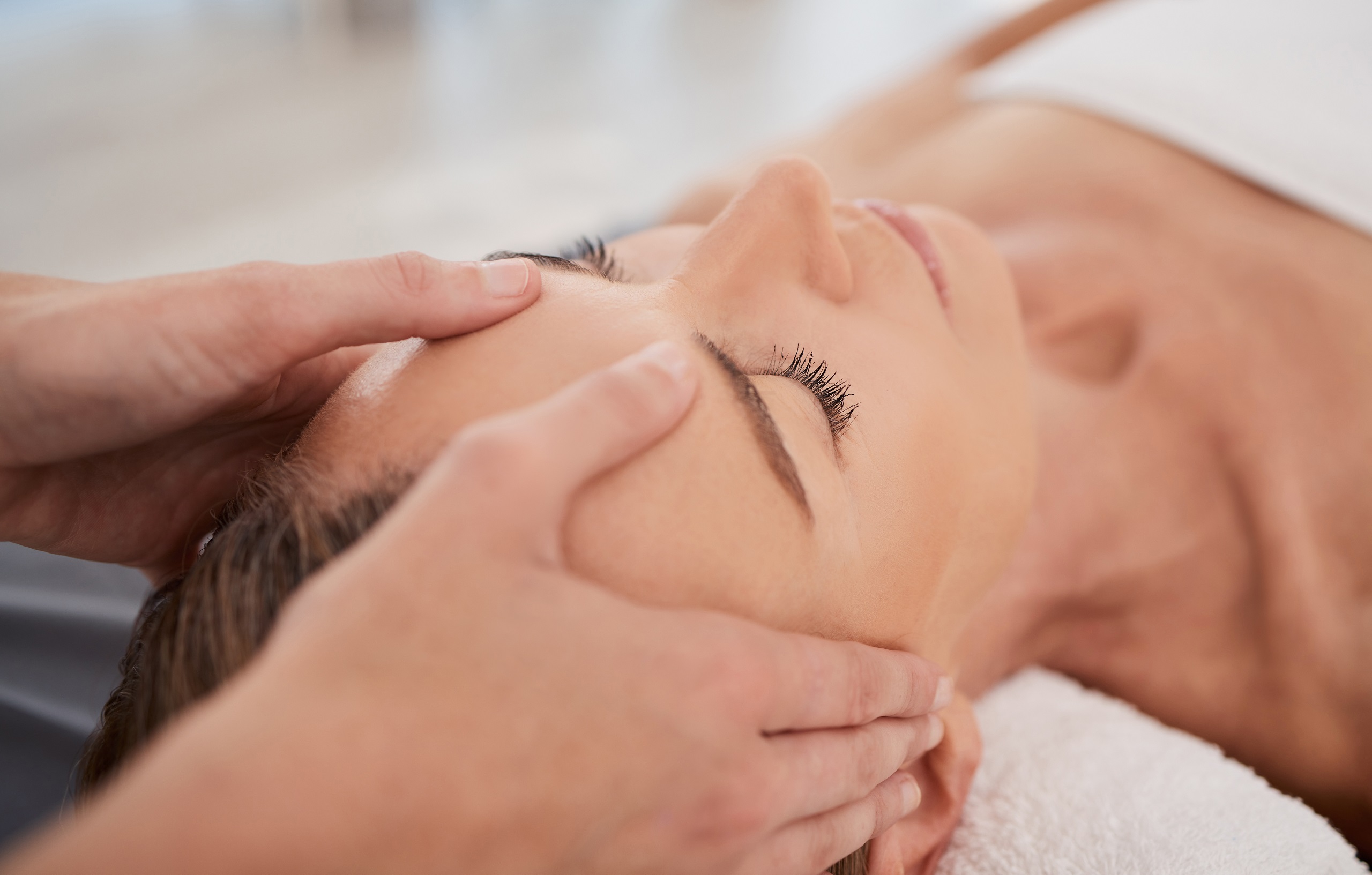 Spa, relax and hands with a head massage for facial wellness, luxury therapy and sleep. Skincare, health and a masseuse massaging temple of a woman at a salon for reflexology and acupressure.